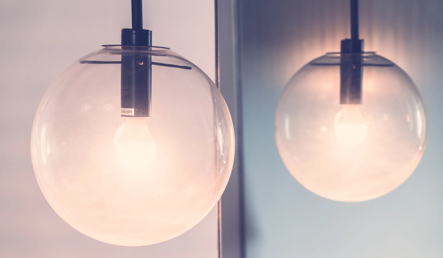 Dos lámparas globo iguales encendidas, una con luz cálida y otra con luz fría