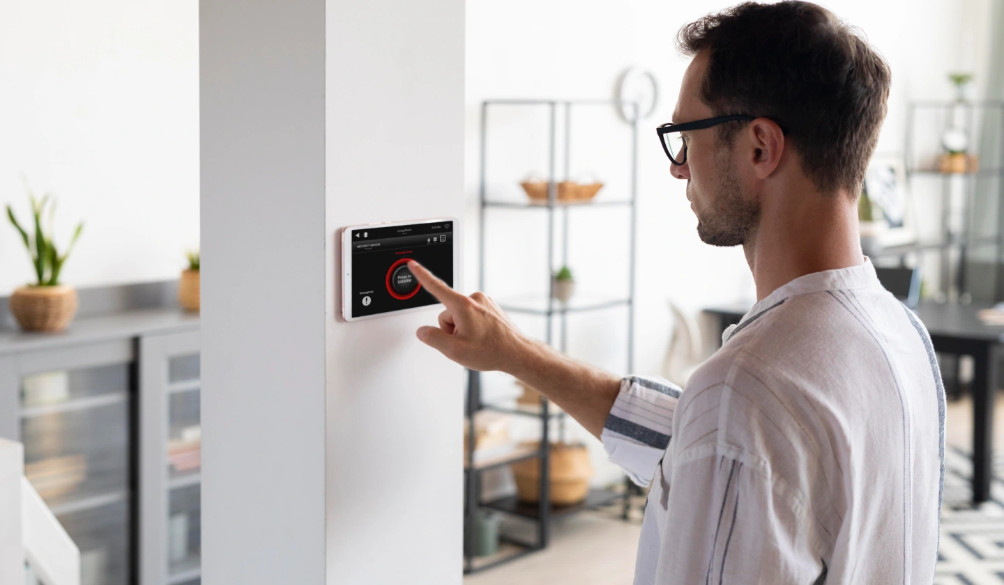 Usuario ajustando un panel de control de temperatura en la pared de una vivienda