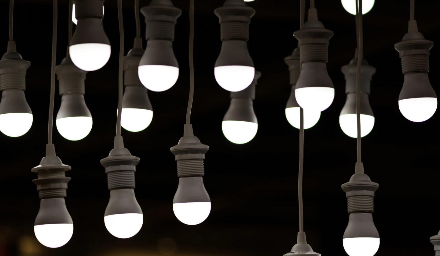 Bombillas LED encendidas colgando de portalámparas E27 sobre fondo oscuro