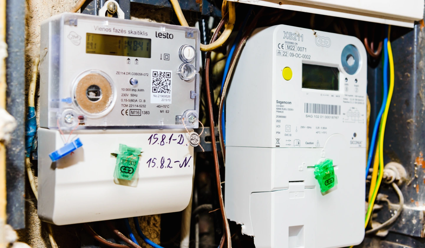 Dos contadores electrónicos de energía con pantalla LCD y precintos dentro de un armario de acometida